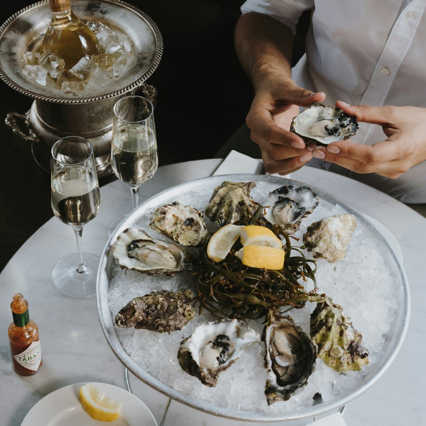 Assiette d’huîtres ouvertes tenue à deux mains
